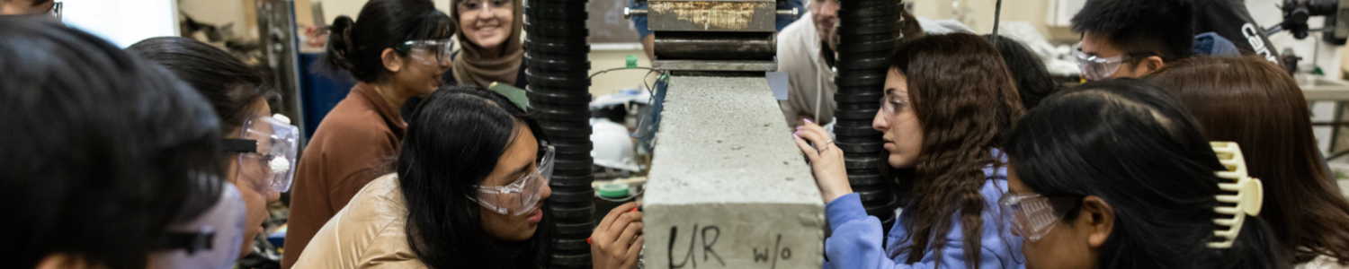 Students crowded around an engineering machine.