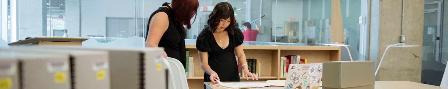 A student and teacher researching in a library.